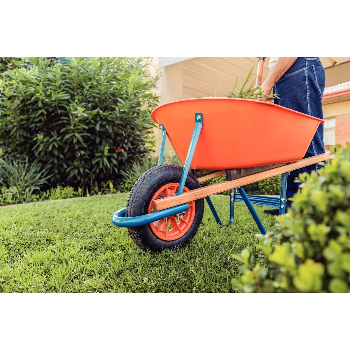 Carrinho de Mão Tramontina com Caçamba Funda Plástica Laranja 55 L, Braço de Madeira e Pneu com Câmara